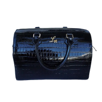 Black patent croc leather duffle bag with gold hardware and stitched handles.