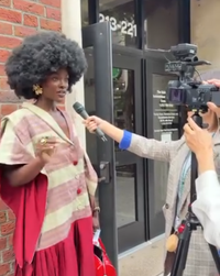 Woman being interviewed by a cameraman outside a building