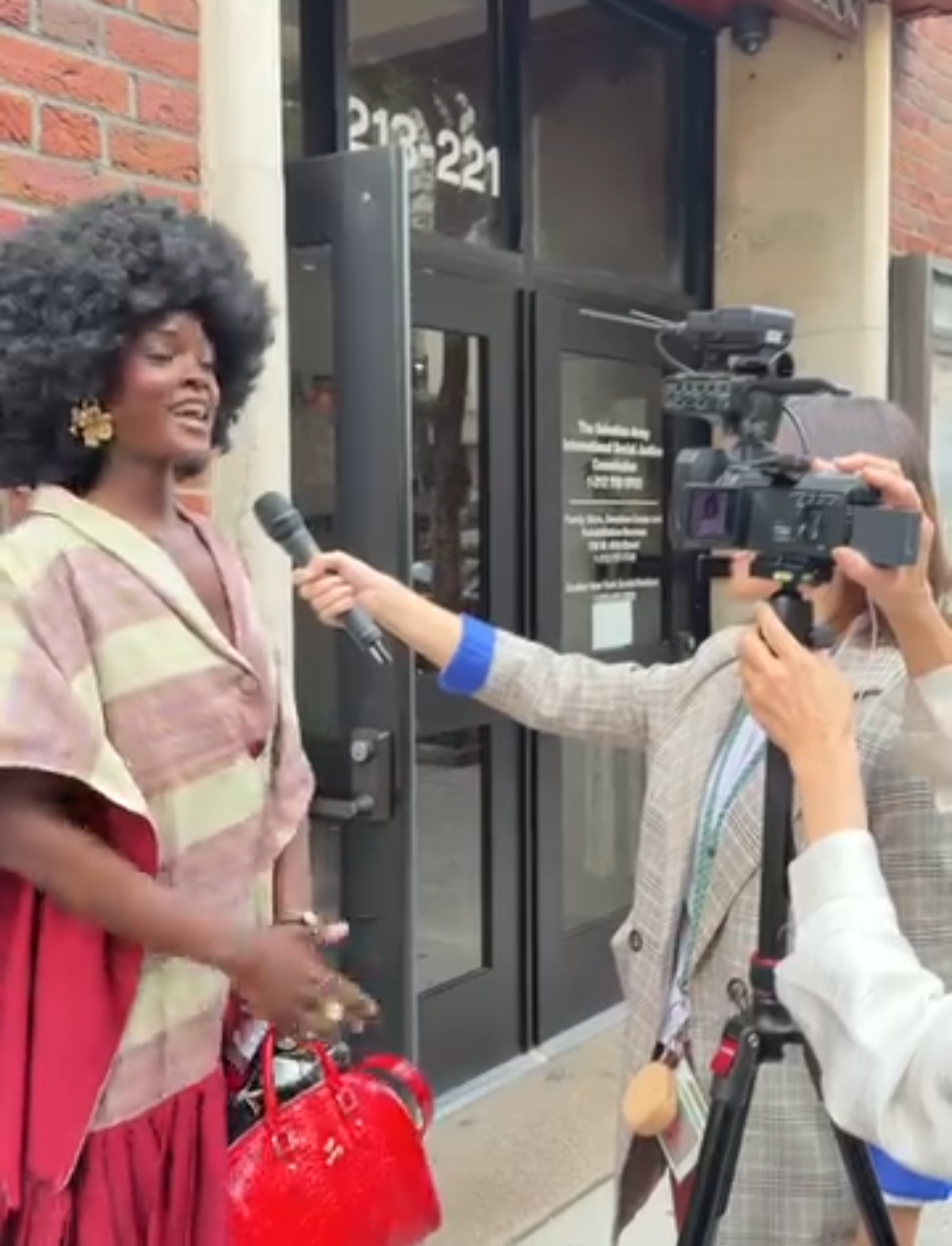 Woman being interviewed by reporters outside a building