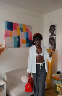 Woman standing in a room with colorful abstract art and a couch.