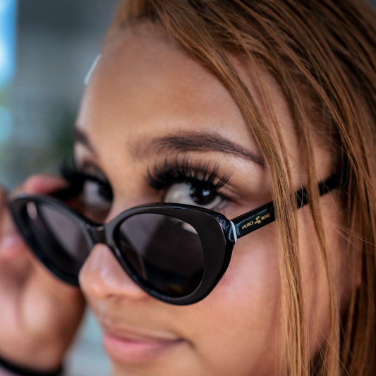 Close-up of a person wearing black sunglasses with a blurred background