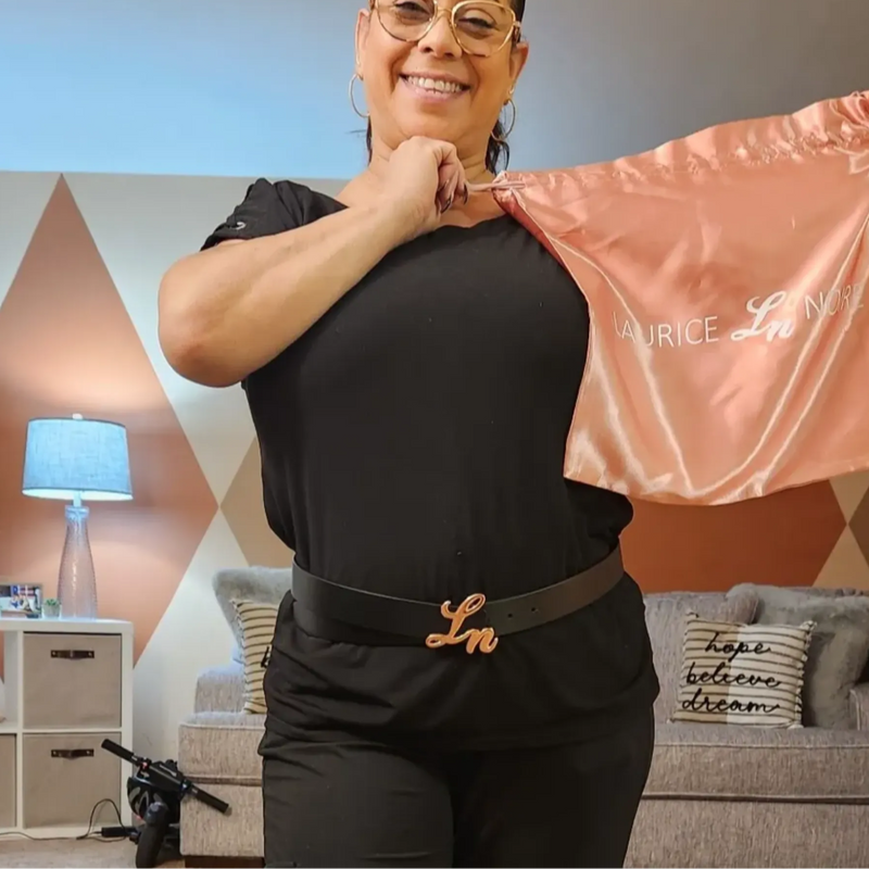 Woman holding a pink dustbag with 'Laurice Noire' branding in a living room setting.